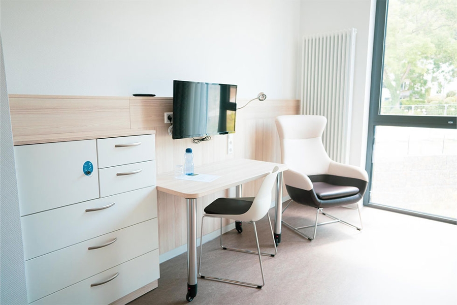 ein Zimmer mit Schreibtisch, Stuhl, Sessel und Fernseher. ein Zimmer mit Schreibtisch, Stuhl, Sessel und Fernseher.