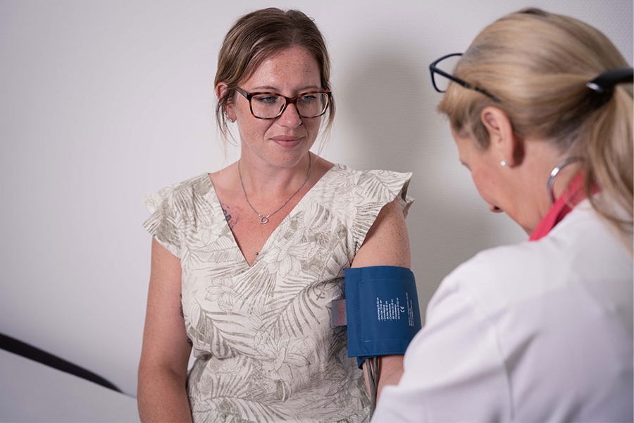 Eine Frau bekommt von einer Ärztin den Blutdruck gemesssen.