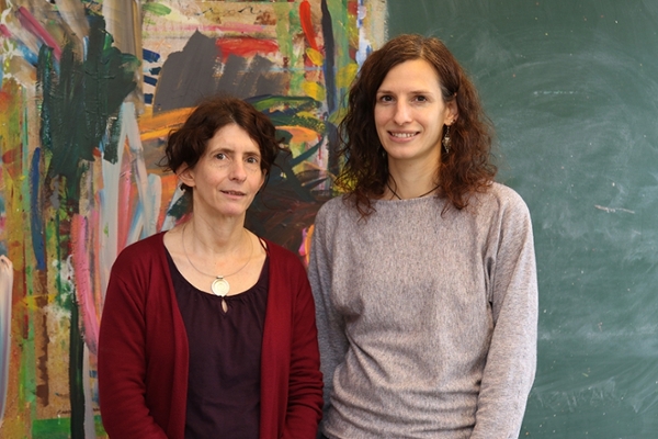 Zwei Frauen stehen vor einer bunten Wand. Zwei Frauen stehen vor einer bunten Wand.