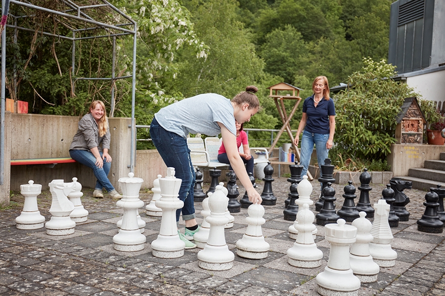 Vier Personen spielen Schach im Freien.