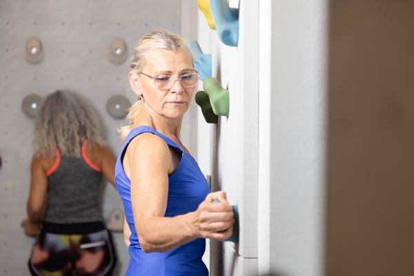 Eine Frau klettert an einer Kletterwand. Eine Frau klettert an einer Kletterwand.