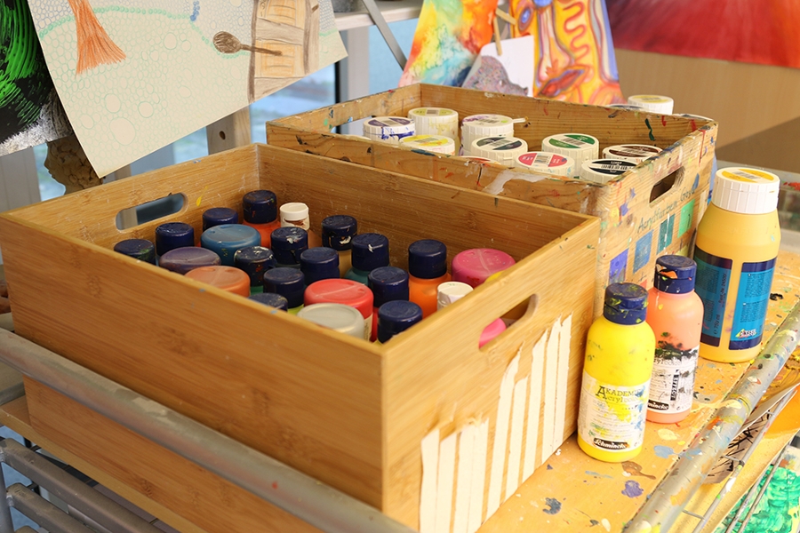 Mehrere Farbflaschen stehen in zwei Holzkisten. Mehrere Farbflaschen stehen in zwei Holzkisten.