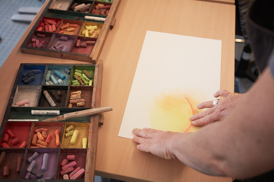 eine Person bemalt ein weißes Blatt Papier mit Kreide. eine Person bemalt ein weißes Blatt Papier mit Kreide.