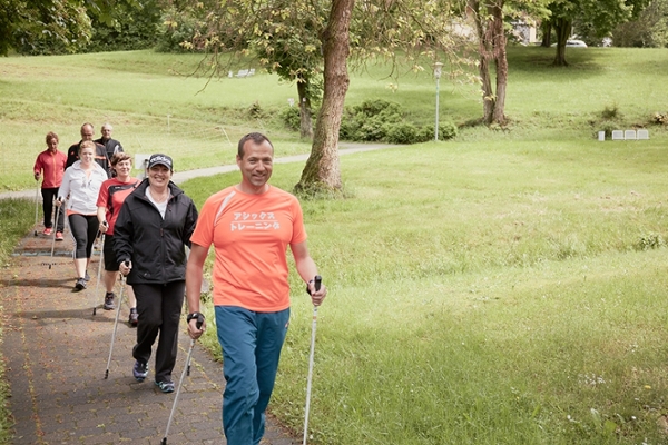 eine Gruppe von Menschen beim Nordic Walking eine Gruppe von Menschen beim Nordic Walking