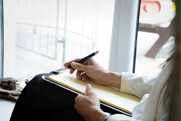 Eine Psychotherapeutin macht sich während einer Therapiesitzung Notizen. Eine Psychotherapeutin macht sich während einer Therapiesitzung Notizen.